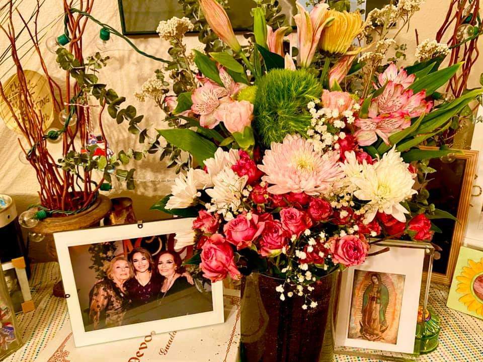 Flowers surrounding a framed photograph of three women in the family